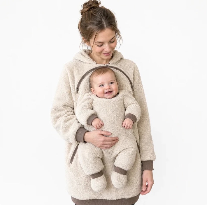 Mother wearing a cream CuddleHood with her baby